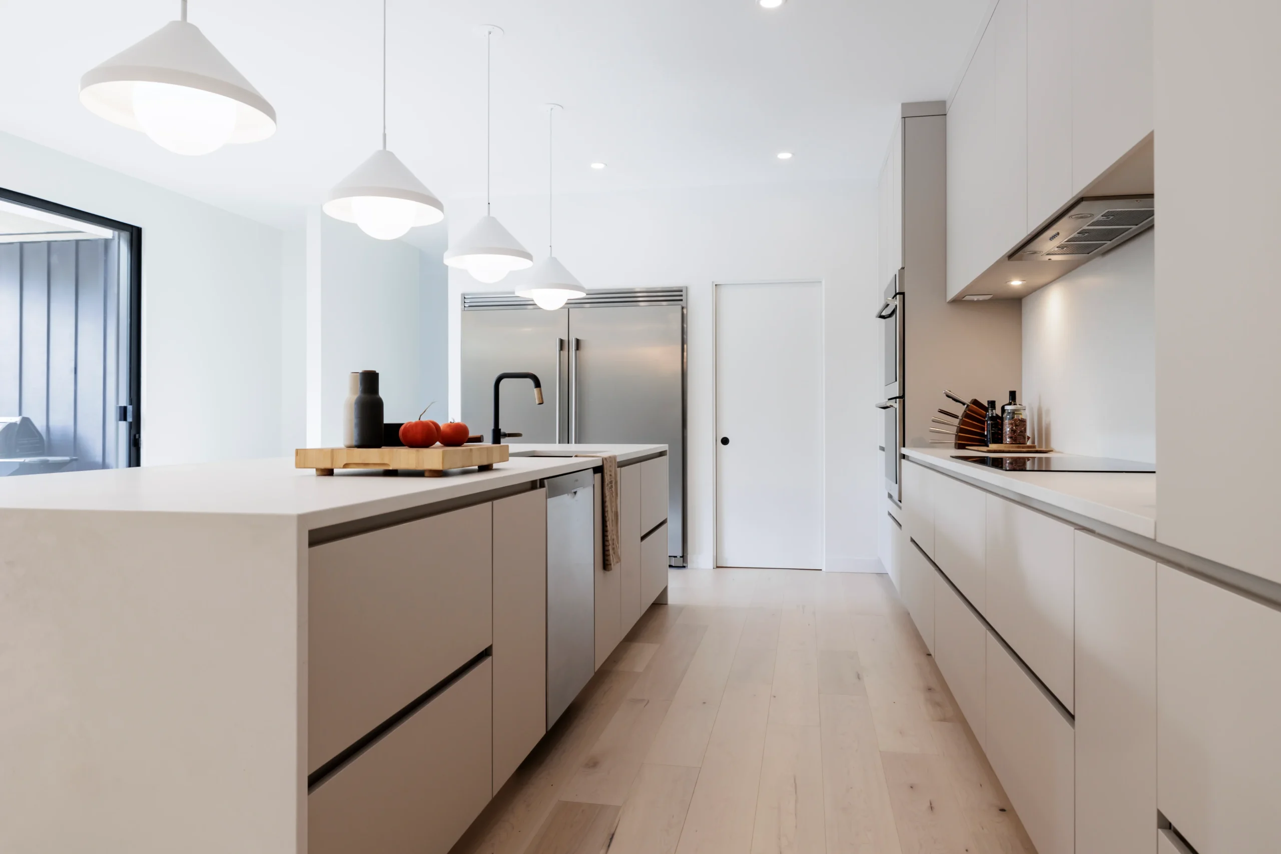 Bright galley kitchen with storage on two walls and a central island for efficient movement.