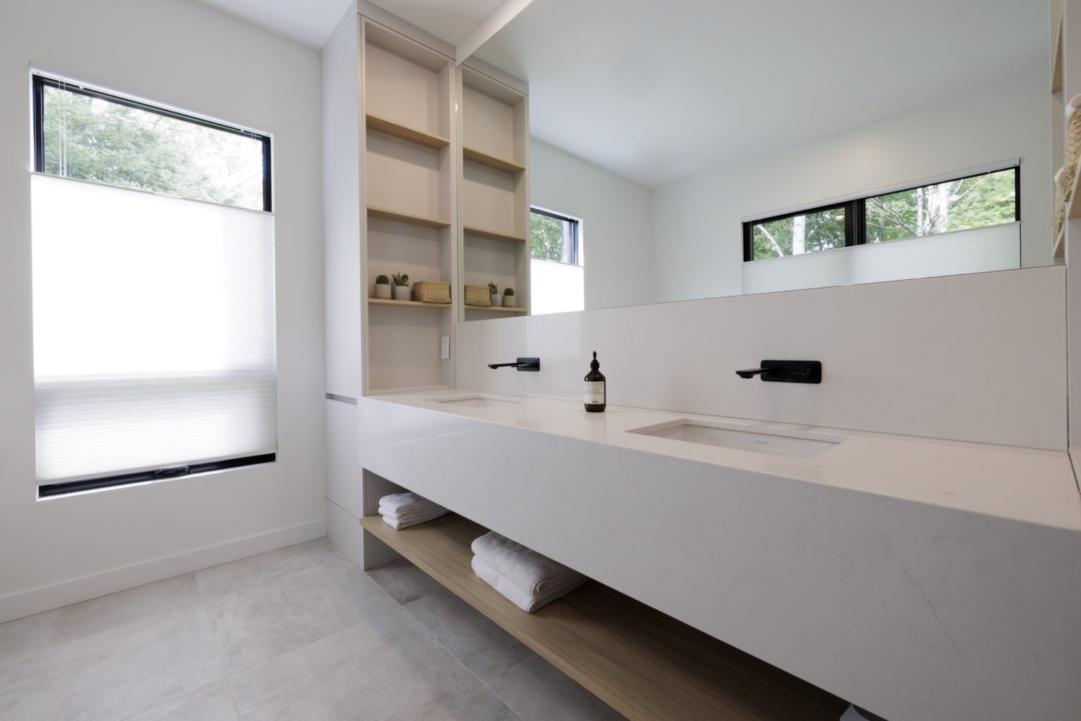 Salle de bain contemporaine avec meuble double vasque blanc et étagères ouvertes décorées de plantes | Contemporary bathroom with white double sink vanity and open shelves decorated with plants