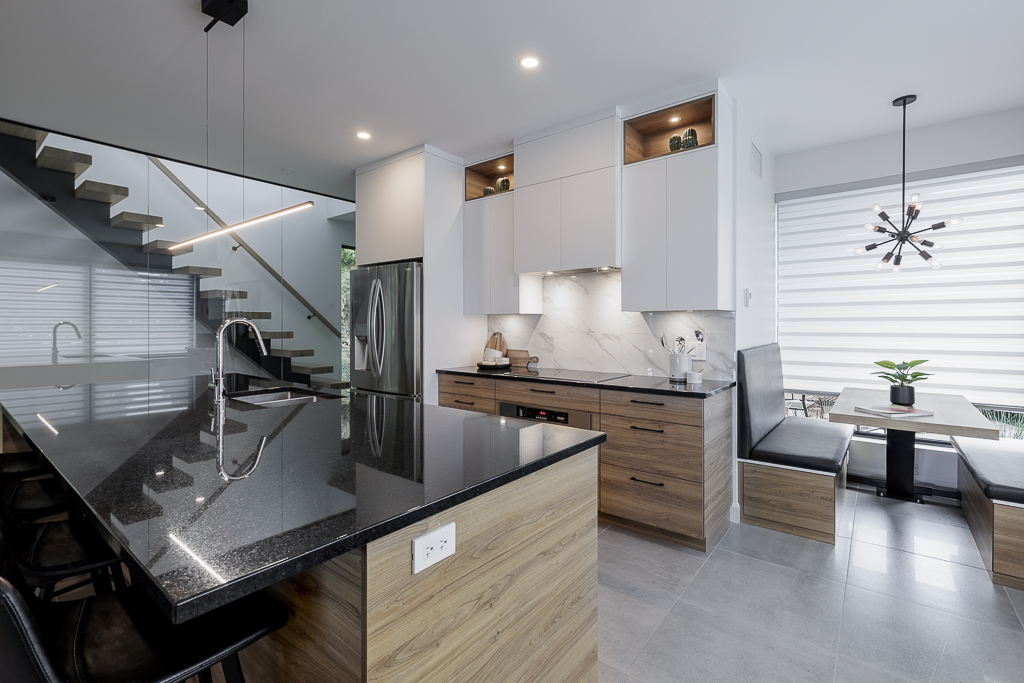 A kitchen with white cabinets and colored countertops.