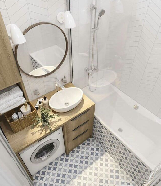 petite salle de bain avec comptoirs en bois et grand miroir rond