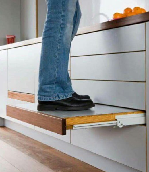 view of a person standing on an integrated step stool drawer