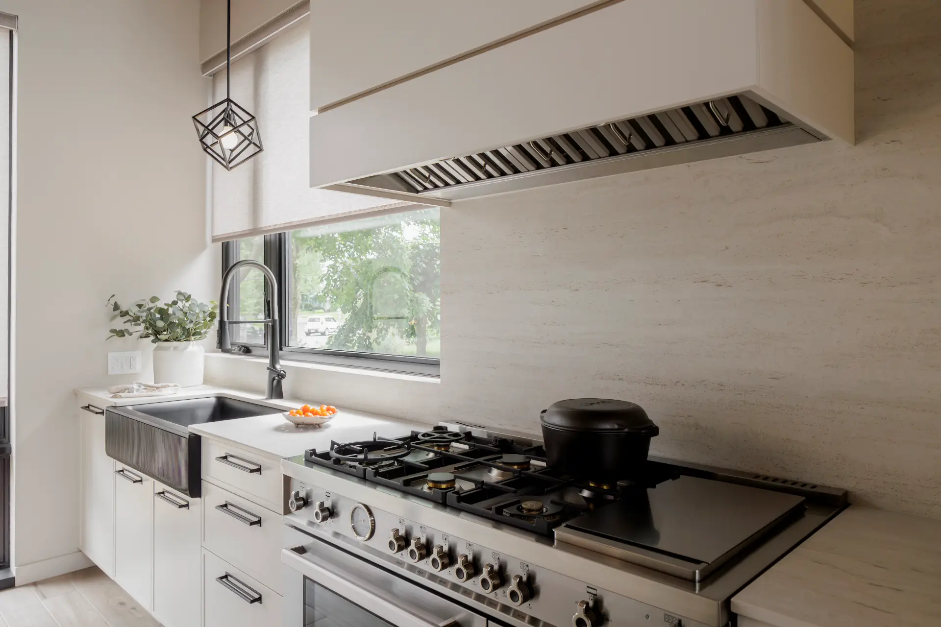 Kitchen renovation idea with a decorative built-in range hood and a clean mineral backsplash.