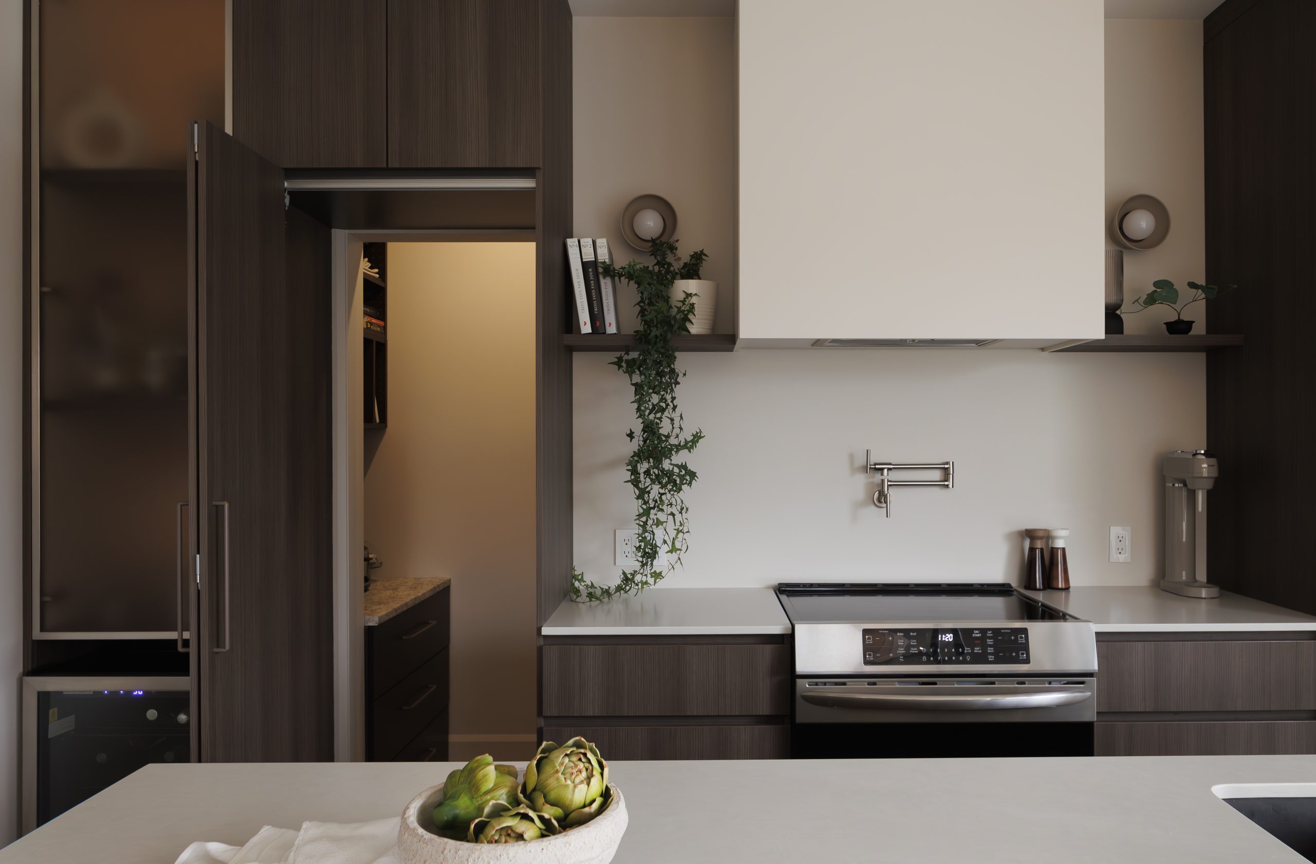 Sleek modern kitchen renovation idea with dark cabinetry, straight lines and integrated appliances.
