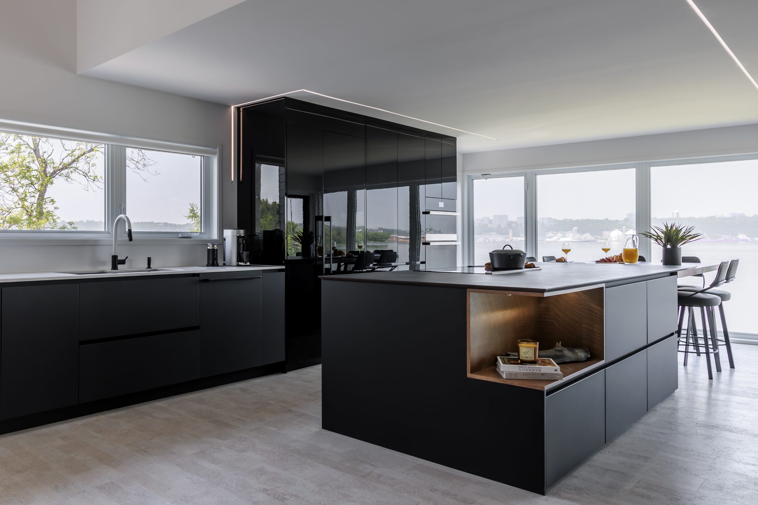 Sophisticated black kitchen renovation idea with matte finishes, a wood niche and panoramic view.