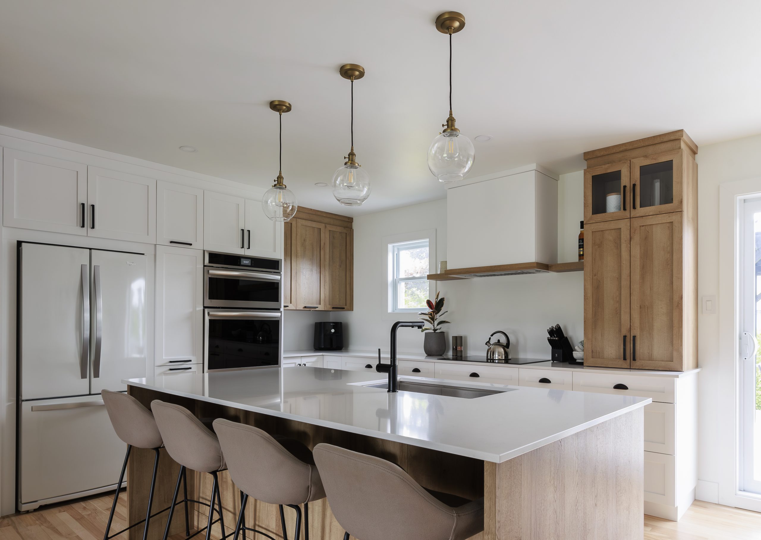 Farmhouse kitchen renovation idea with white cabinets, natural wood and a bright central island.