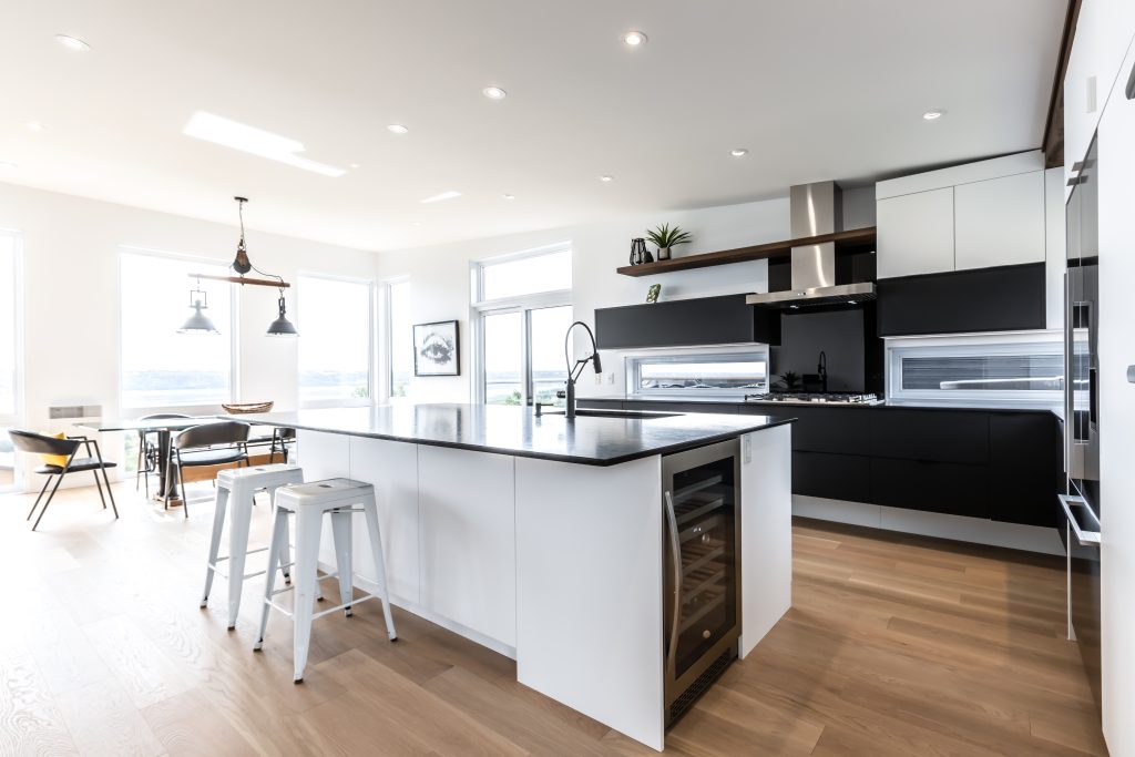 Wide view of a kitchen with a mix of black and white cabinets.