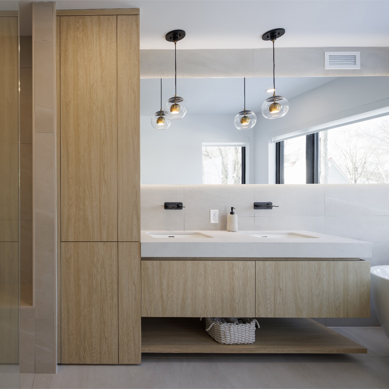 Bathroom with tall light wood cabinet and black pendant lights