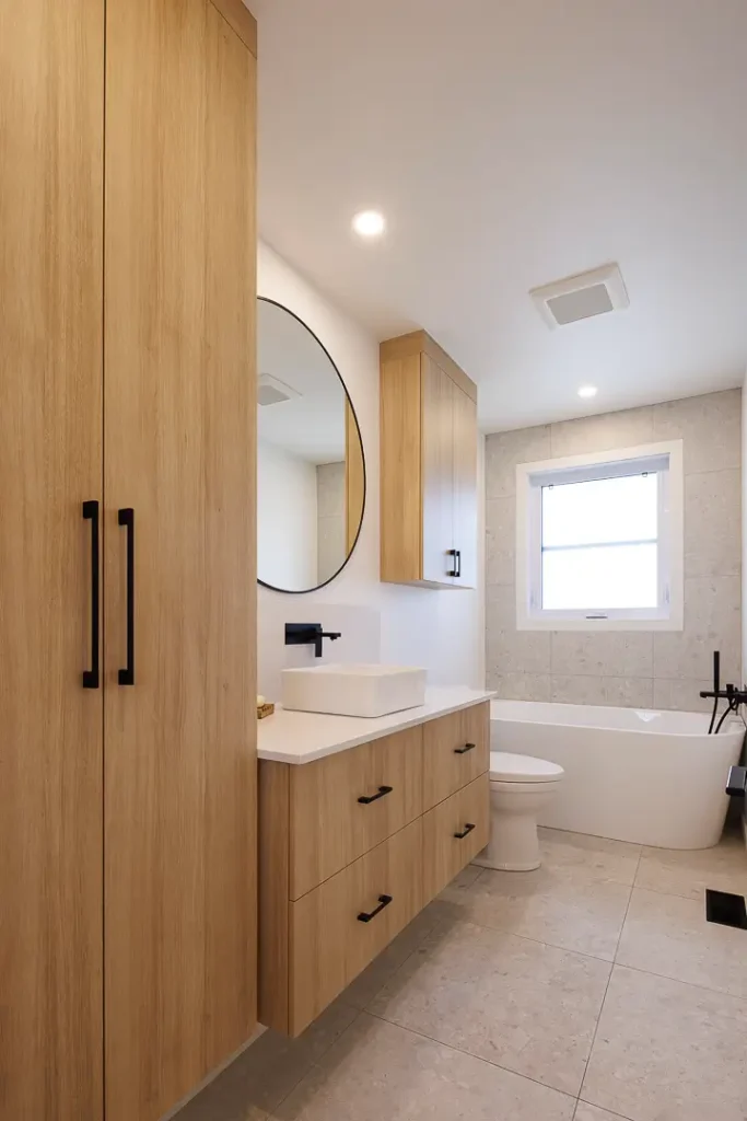 Salle de bain moderne avec armoires en bois clair et lavabo rectangulaire | Modern bathroom with light wood cabinets and rectangular sink