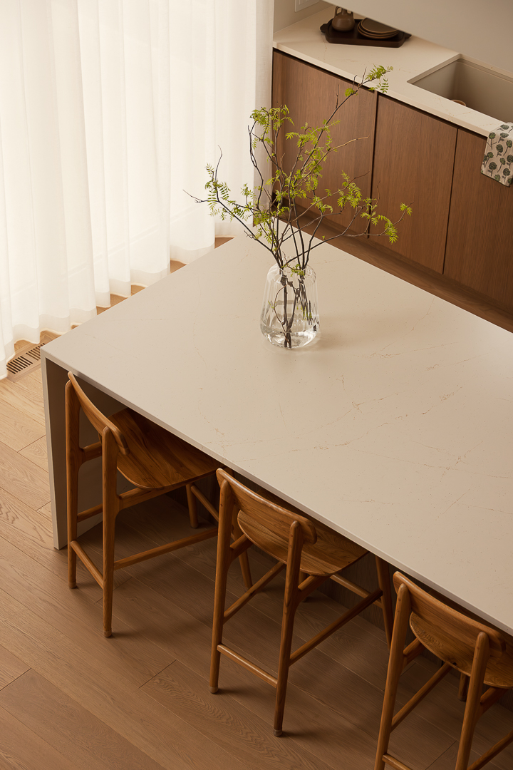 Kitchen island with dining area and light countertop in a modern kitchen.